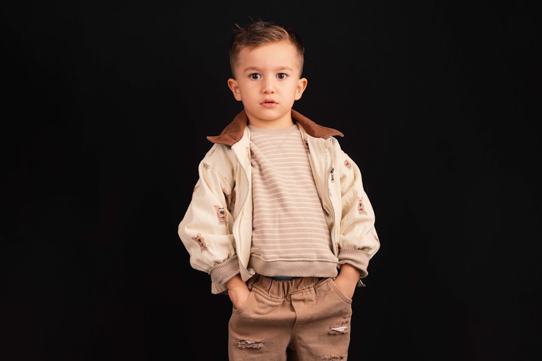 About young-boy-in-stylish-outfit-stands-against-black-background-gwxssjth4ye